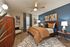 Contemporary bedroom with elegant decor, featuring a plush bed, stylish ceiling fan, and chic blue accent wall.