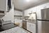 Modern kitchen featuring granite countertops, sleek stainless steel appliances, and elegant white cabinetry, offering a sophisticated cooking experience.