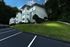 Charming apartment building nestled in a lush green setting, featuring modern architecture and ample parking space.