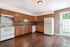 Beautiful kitchen with warm wooden cabinetry, modern appliances, and natural light from a glass patio door.