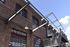 Charming urban loft building with rustic brick exterior, featuring inspirational wall art and modern steel staircases under a bright blue sky.