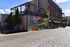 Vibrant urban scene with colorful street art mural on an industrial-style building, under a clear blue sky.