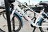 Modern, sleek white bicycles with blue accents parked neatly in a vibrant apartment community parking area offering convenience and style.