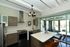 Modern kitchen with sleek appliances, stylish island, and large glass doors opening to a bright outdoor view.