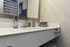 Elegant bathroom vanity featuring a sleek countertop with modern accessories and chic wall art, perfect for a luxurious home.