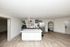 Modern open-concept kitchen with sleek marble island, stainless steel appliances, and elegant wood flooring.
