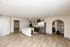Modern kitchen design with sleek stainless steel appliances, elegant marble countertops, and open shelving, set against stylish wood flooring and spacious layout.