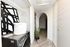 Chic laundry area with modern washer, abstract art, and vibrant snake plant in a bright hallway.