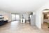 Bright and spacious open-plan living area with modern kitchen and large windows, perfect for contemporary living.