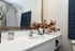 Elegant bathroom vanity with a modern sink, chic decor, and a large mirror enhancing natural light.