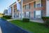Charming brick apartment building with elegant columns and well-maintained landscaping, featuring the Kensington flag for a welcoming entrance.