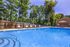 Charming outdoor pool area with crystal-clear water, surrounded by lush greenery and inviting lounge chairs for relaxation.