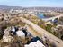 Scenic aerial view of a vibrant urban landscape along a river, featuring bridges, lush greenery, and charming residential buildings.