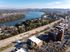 Stunning aerial view of a serene riverside neighborhood with lush greenery and modern architecture, offering a picturesque living environment.