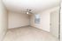 Bright, airy bedroom with plush carpet, modern ceiling fan, and large window for natural light.