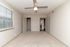 Inviting bedroom with plush carpet, modern ceiling fan, and ample natural light from large window.