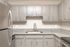 Modern kitchen with sleek stainless steel appliances, elegant granite countertops, and stylish gray cabinetry.