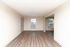 Bright, open living space featuring elegant hardwood flooring and modern window blinds, perfect for a cozy, versatile setup.