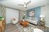 Chic and inviting living room with modern decor, featuring a cozy white armchair, stylish wooden coffee table, and a contemporary sofa set against a soothing blue accent wall.