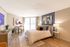 Bright and stylish bedroom with modern decor, featuring a cozy bed, chic artwork, and a sunlit balcony view.
