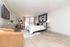 Bright and spacious bedroom featuring modern decor, large bed, and elegant wooden flooring, perfect for a cozy retreat.
