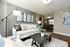Modern and inviting living room with sleek decor, plush seating, and stylish artwork, opening to a cozy dining area.