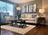 Elegant living room with modern decor, featuring a cozy beige sofa, stylish armchair, and ambient lighting for a welcoming ambiance.