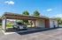Spacious covered parking area with a sleek silver SUV, set against a backdrop of lush greenery and neatly arranged garages.