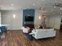 Inviting modern living room with stylish hardwood flooring, cozy seating area, wall-mounted TV, and elegant lighting, ideal for relaxation and entertainment.