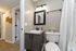 Elegant bathroom with modern lighting, granite countertop, and decorative floral accents.