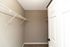 Spacious walk-in closet with sleek white wire shelving, perfect for ample storage and organization.