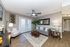Elegant living room featuring chic decor, plush seating, large mirror, and natural light through French doors.