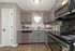 Contemporary kitchen with sleek gray cabinetry, stainless steel appliances, and elegant tile backsplash, perfect for modern living.