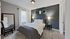 Inviting bedroom with plush bedding, stylish dark accent wall, and elegant decor in a serene setting.