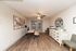 Inviting workspace with elegant wooden flooring, modern artwork, and ample natural light from French doors.
