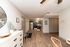 Modern open-concept kitchen and entryway with sleek cabinetry and stylish flooring, radiating warmth and sophistication.