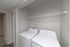 Modern laundry area with sleek washer and dryer, featuring convenient shelving in a bright, functional space.