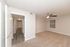 Inviting room with plush carpet, a ceiling fan, and a view down a hallway with elegant wood flooring.