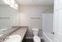 Modern bathroom with sleek granite countertop, large mirror, and bright lighting, offering a fresh and inviting atmosphere.