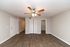 Bright living area with elegant hardwood floors, ceiling fan, and spacious closet space, ideal for stylish living.