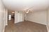 Spacious open-plan living area with modern ceiling fan, hardwood flooring, and sleek stainless steel kitchen appliances.