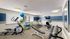 Modern apartment gym with cardio equipment, free weights, and exercise balls, offering a bright and energized workout space.