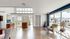 Bright and inviting living space with large windows, modern furnishings, and elegant wooden flooring.