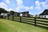 Charming residential community featuring stylish two-story buildings and lush green lawns, set under a bright blue sky.