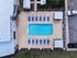 Inviting aerial view of a modern apartment complex featuring a pristine swimming pool surrounded by sun loungers and shaded cabanas, perfect for relaxation.