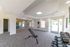 Bright, modern gym space with large windows, fitness ball stack, weights, and multifunctional bench.