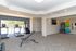 Modern fitness center featuring treadmills, stair climber, weight bench, and vibrant exercise balls, bathed in natural light.