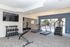 Modern gym with state-of-the-art exercise equipment, including treadmills and weights, overlooking a refreshing pool area.