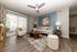 Inviting living room with a modern ceiling fan, stylish furniture, and natural light streaming through large sliding glass doors.