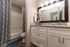 Elegant bathroom with stylish granite countertops, soft lighting, and modern fixtures; features a chic shower curtain and decorative accents for a luxurious feel.